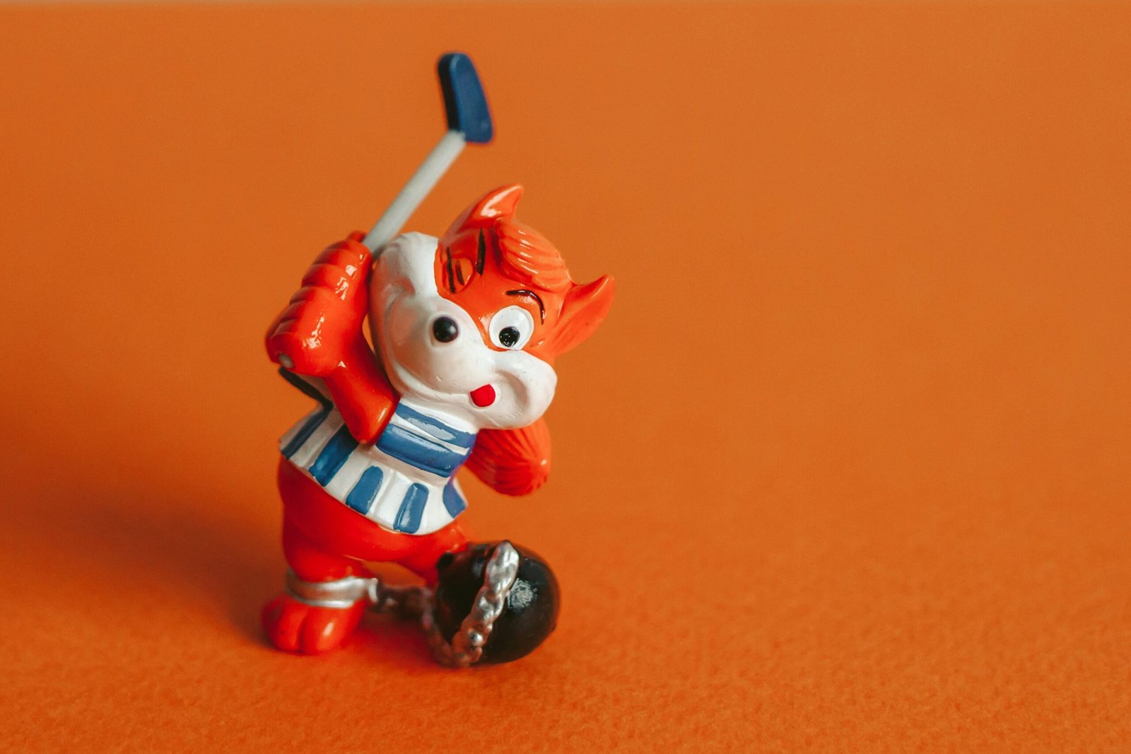 A figurine of a clown holding a baseball bat